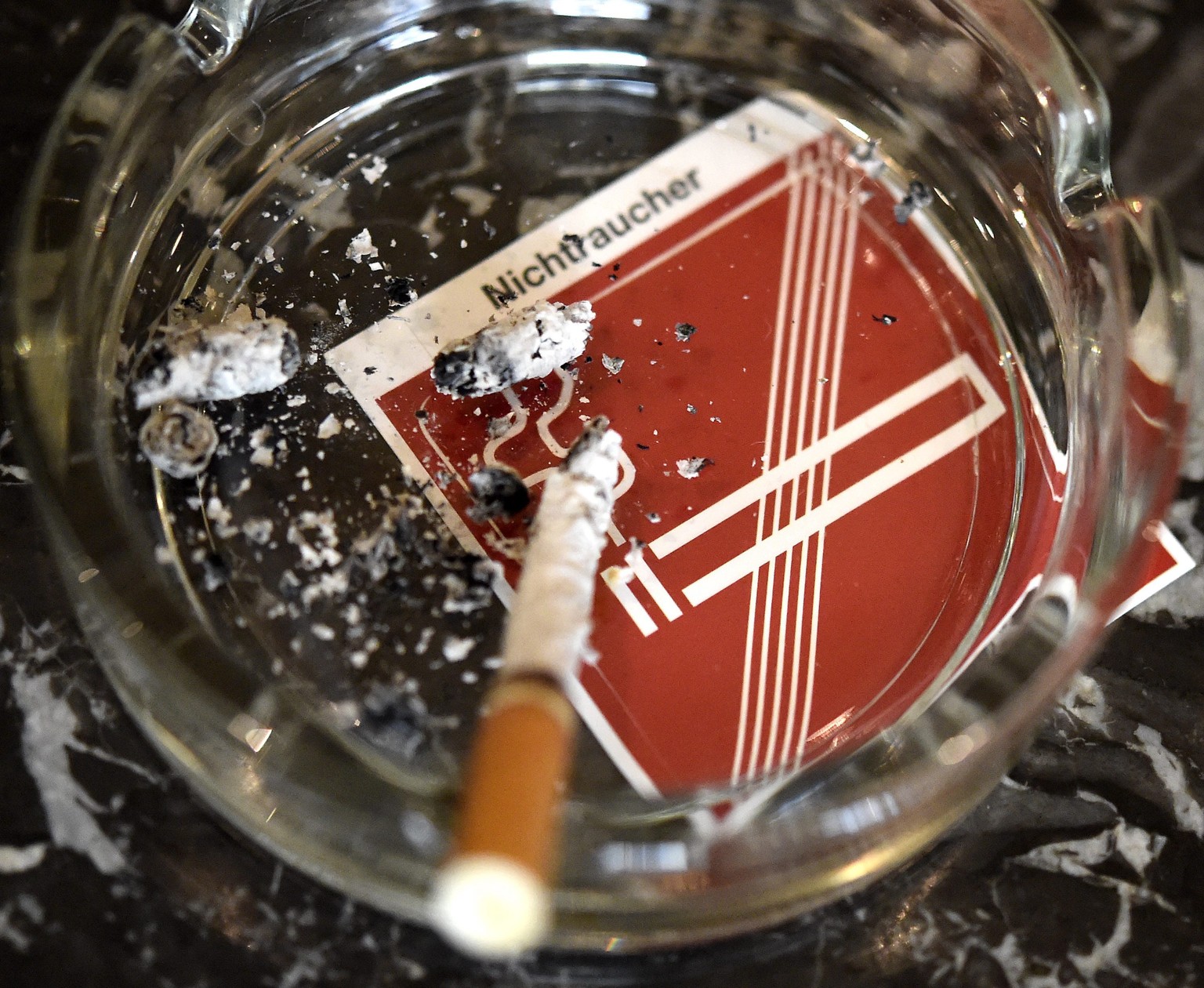 epa04698606 An archive picture made available on 10 April 2015 of a cigarette resting inside an ashtray on top of a non-smoking sign at a cafe in Vienna, Austria, 07 January 2015. Austrian restaurants ...