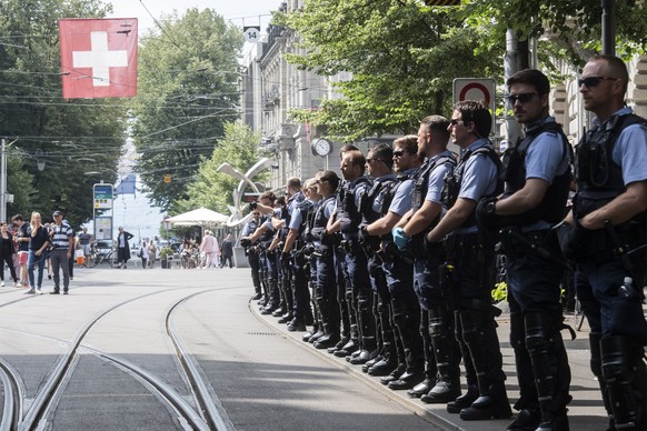 Polizisten stehen vor den Klimaaktivisten der Organisation Clima Justice welche den Eingang der Schweizer Bank Credit Suisse blockieren, aufgenommen am Montag, 8. Juli 2019 auf dem Paradeplatz in Zuer ...