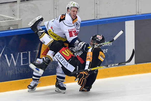 Lugano&#039;s player Maxim Lapierre, right, fights for the puck with Zug&#039;s player Johann Morant, left, during the preliminary round game of National League A (NLA) Swiss Championship 2016/17 betw ...