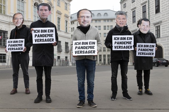 Protesters stand in front of the federal chancellery of Austria, wearing mask of the political leaders of Austria with a sign that says �� I am a pandemic failure&quot; in Vienna, Austria, Monday, Nov ...