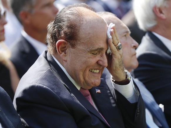 FILE - In this July 29, 2019 file photo, Rudy Giuliani, an attorney for President Donald Trump, left, wipes his forehead as he listens to President Donald Trump speak in the Rose Garden of the White H ...