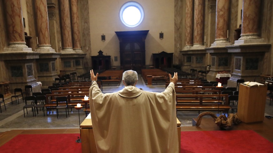 Don Angelo Riva celebrates a mass in an empty church after Italy's lockdown measure to prevent the spread of Covid-19, in Carenno, Italy, Thursday, April 2, 2020. The new coronavirus causes mild ...