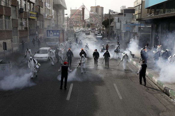 Firefighters disinfect a street against the new coronavirus, in western Tehran, Iran, Friday, March 13, 2020. The new coronavirus outbreak has reached Iran&#039;s top officials, with its senior vice p ...