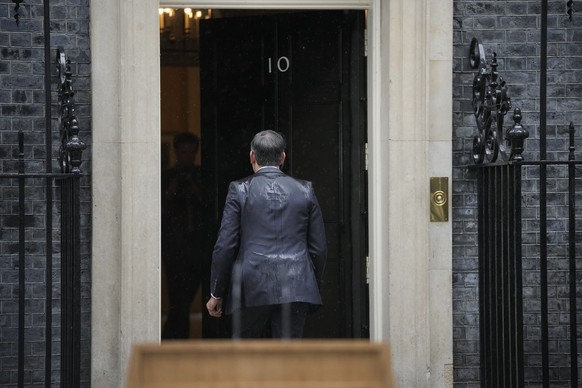 Britain&#039;s Prime Minister Rishi Sunak walks back into 10 Downing Street in London Wednesday, May 22, 2024, after he announced that he is to call a General Election for July 4. Heavy rain fell duri ...