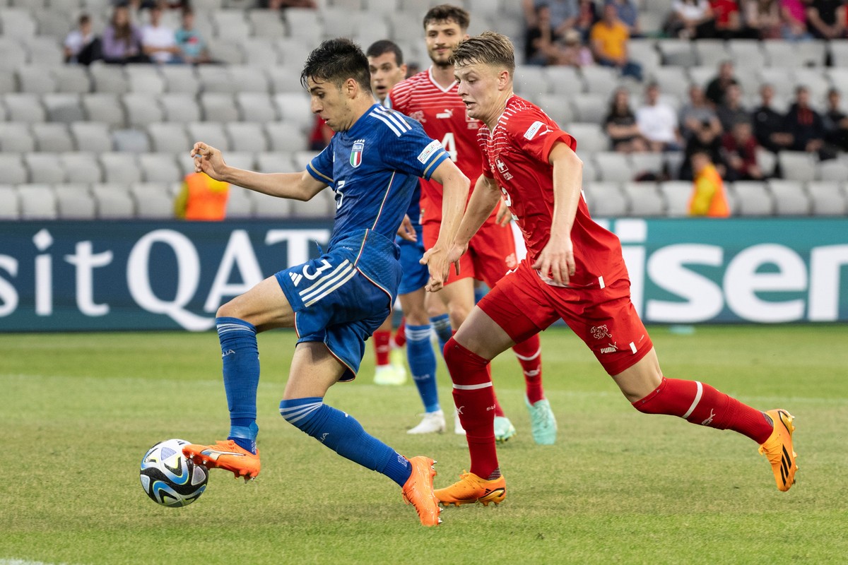 epa10711175 Italy's Fabiano Parisi (L) fights for the ball with Switzerland's Lewin Blum during the UEFA Under-21 Championship group stage match between Switzerland and Italy in Cluj, Romani ...