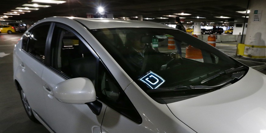 File- This March 31, 2016, file photo shows a driver for Uber Technologies Inc., arriving at an authorized customer pick up area at Seattle-Tacoma International Airport in Seattle. Uber will start kee ...