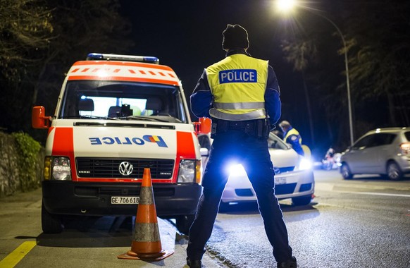 Des policiers controlent des automobilistes lors d&#039;un controle de circulation comprenant la police et la gendarmerie genevoise et vaudoise ainsi que les gardes frontieres ce mardi soir 23 decembr ...