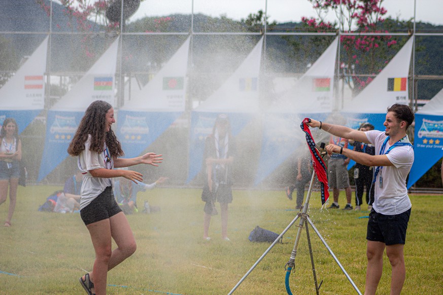 Swiss scouts having fun with the water from the sprinkler during the Jamboree heat World Scout Jamboree