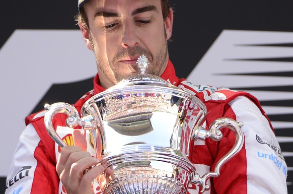 Ferrari driver Fernando Alonso of Spain looks at his trophy after winning the Formula One Spanish Grand Prix at the Catalunya racetrack in Montmelo, near Barcelona, Spain, Sunday, May 12, 2013. (AP Ph ...