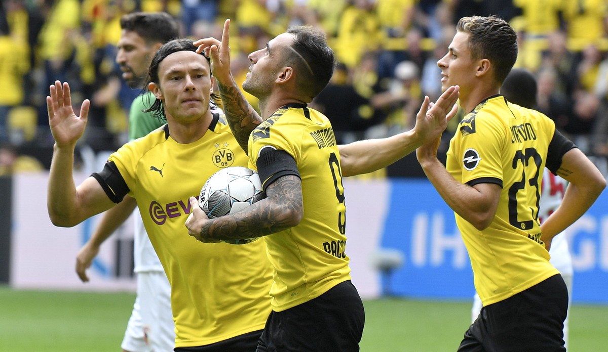 Dortmund's Paco Alcacer, center, celebrates after scoring his side's first goal during the German Bundesliga soccer match between Borussia Dortmund and FC Augsburg at the Signal Iduna Park s ...