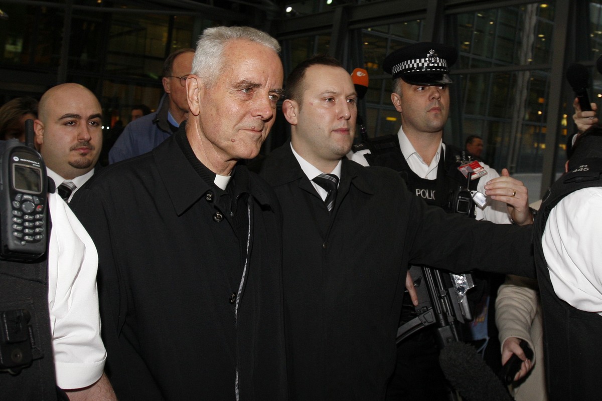 FILE - Bishop Richard Williamson, foreground left, is escorted out of Heathrow airport by police and security officers after arriving on a flight from Argentina, in London, Wednesday, Feb. 25, 2009. ( ...