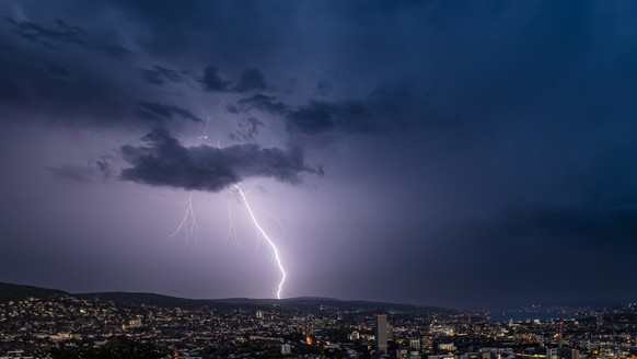 Ein Blitz am Himmel ueber der Stadt Zuerich waehrend eines Gewitters am Donnerstag, 24. August 2023 in Zuerich. (KEYSTONE/Michael Buholzer)
