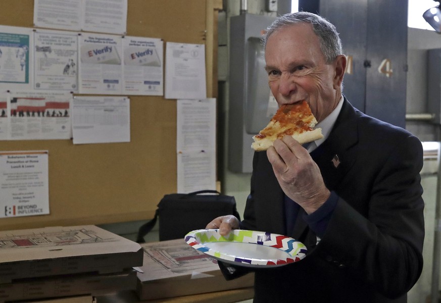 Potential Democratic presidential candidate Michael Bloomberg eats a slice of pizza after a tour of the WH Bagshaw Company, a pin and precision component manufacturer, Tuesday Jan. 29, 2019, in Nashua ...