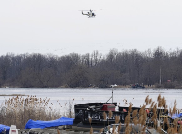 A police helicopter searches an area in Akwesasne, Quebec, Friday, March 31, 2023. Authorities in the Mohawk area of ​​Akwesasne said Friday that one child is missing after the bodies of six migrants from…