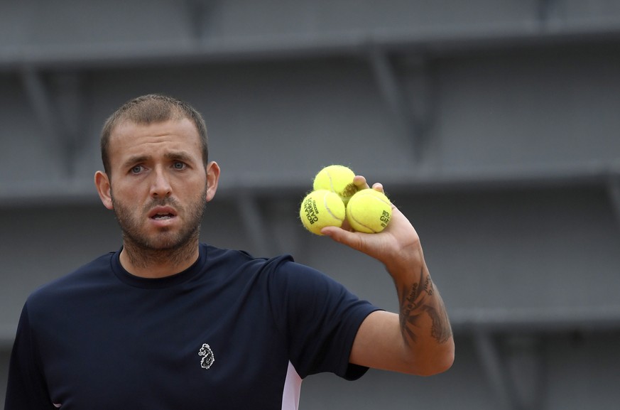 epa08700818 Daniel Evans of Britain with new balls as he plays Kei Nishikori of Japan during their men?s first round match during the French Open tennis tournament at Roland Garros in Paris, France, 2 ...