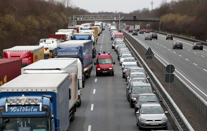 epa06450024 An emergency vehicle of the fire brigade makes its way through a traffic jam while the other vehicles build a rescue lane (Rettungsgasse) on the motorway A2 near Dortmund, Germany, 18 Janu ...