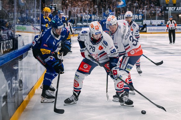 Julien Sprunger (HCFG), gauche, lutte pour le puck avec Thierry Bader (ZSC), et Jan Schwendeler (ZSC), droite, lors du match du championnat suisse de hockey sur glace de National League entre le HC Fr ...