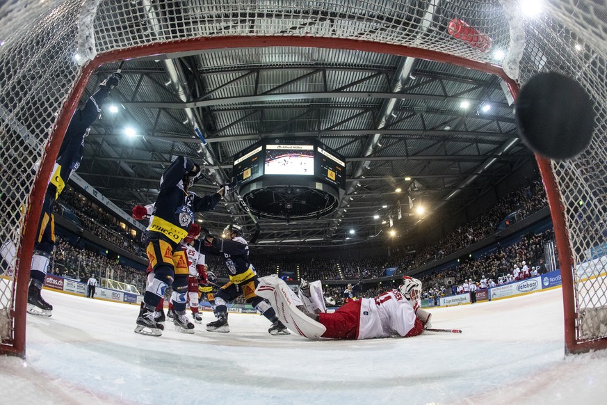 Zugs Yannick Zehnder, Zugs Sven Leuenberger und Lausannes Goalie Sandro Zurkirchen, von links, beim Tor zum 2-0 im fuenften Eishockey Playoff-Halbfinalspiel der National League zwischen dem EV Zug und ...