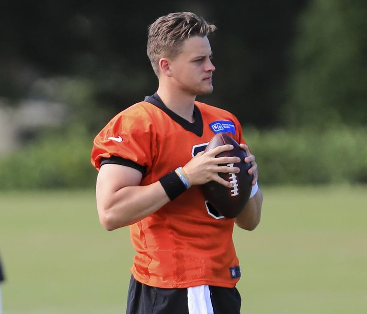 Cincinnati Bengals' Joe Burrow grips a ball while he stands on the field prior to an NFL football camp practice in Cincinnati, Monday, Aug. 17, 2020. (AP Photo/Aaron Doster)