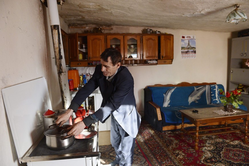 epa04623121 A picture made available on 16 February 2015 shows Kosovo man Shaip Latifi cooks in his home furnished from donations by Austrian charity organizations in Metohi, Kosovo, on the Serbian bo ...