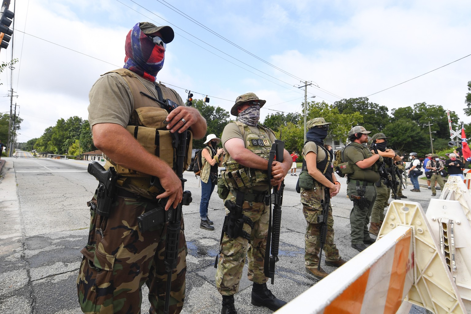 epa08605937 Far-right groups, including militias and white supremacists, demonstrate on Main Street during a rally in Stone Mountain, Georgia, USA, 15 August 2020. The rally was suppopsed to be held a ...