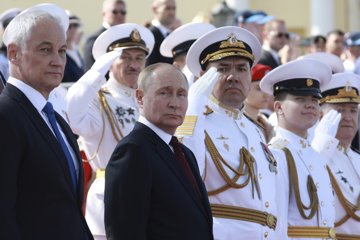 Russian President Vladimir Putin and Russian Defense Minister Andrei Belousov, left, attend the main naval parade marking Russian Navy Day in St. Petersburg, Russia, Sunday, July 28, 2024. (Vyacheslav ...