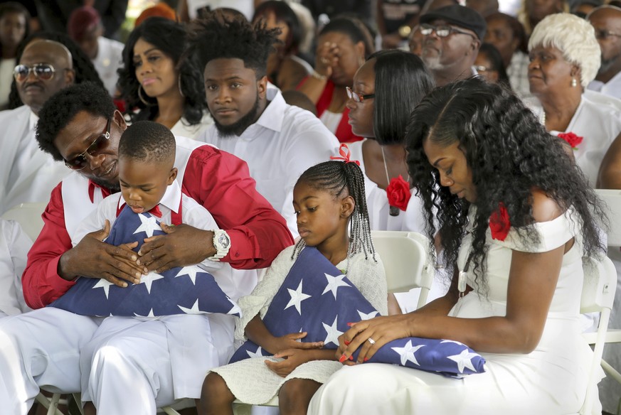 From left, Richard Johnson Sr. holds La David Johnson Jr,. Ah&#039;Leesya Johnson, and Myeshia Johnson, the wife of Army Sgt. La David Johnson, attend Sgt. Johnson&#039;s burial at the Hollywood Memor ...