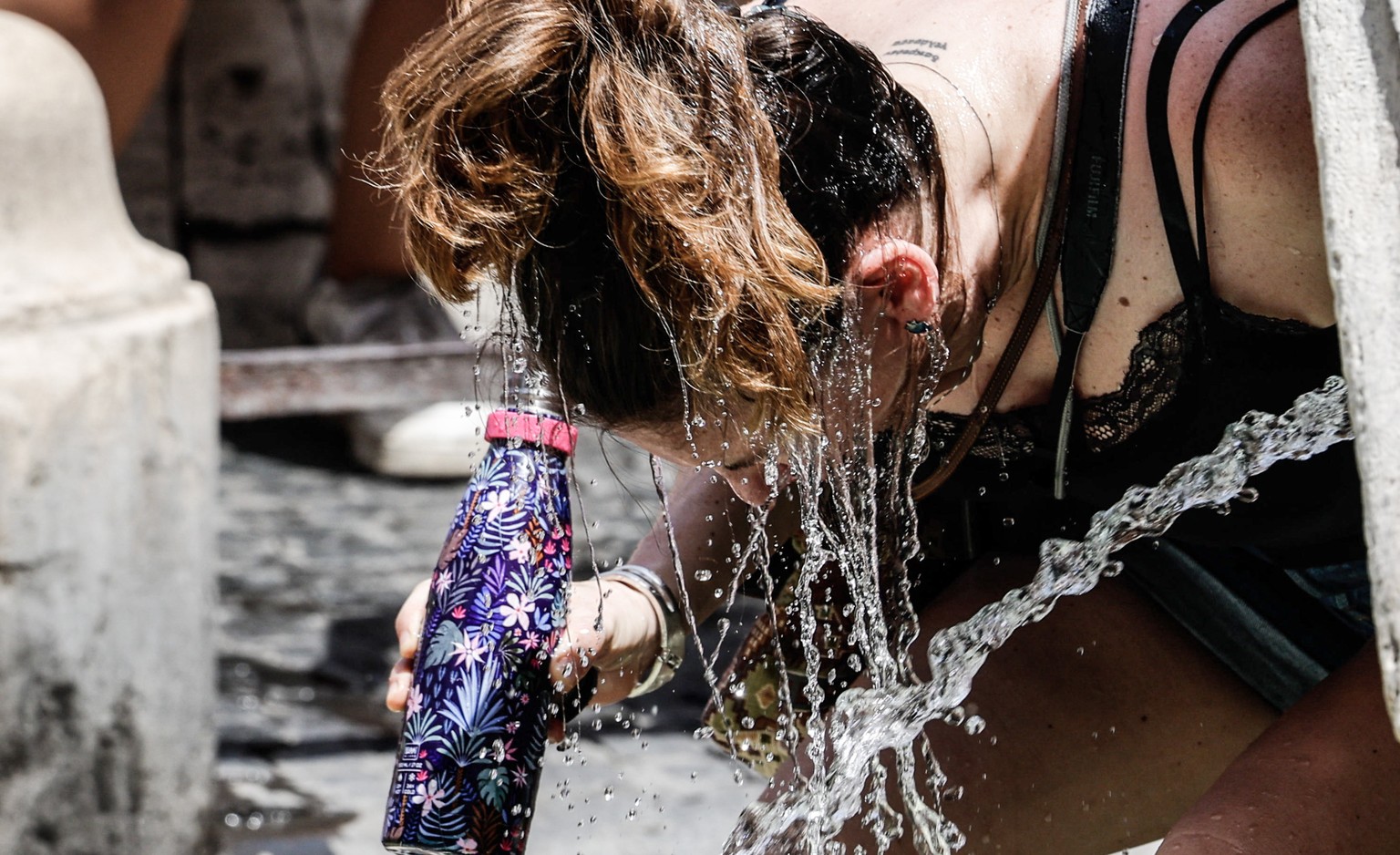 epa10751442 A person pours water to cool off amid high temperatures, in Rome, Italy, 17 July 2023. Southern Europe is experiencing a major heat wave this week with temperatures expected to climb up to ...