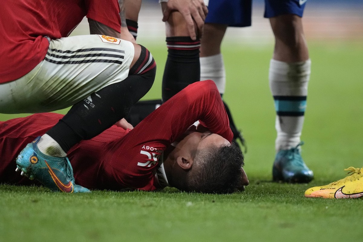 Manchester United's Raphael Varane lies injured on the ground during the English Premier League soccer match between Manchester United and Chelsea at the Stamford Bridge Stadium in London, Saturd ...