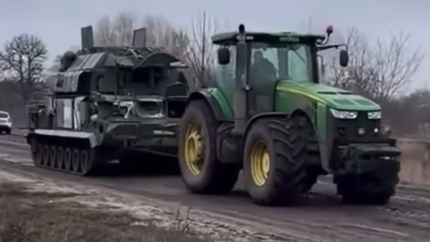 Ein ukrainischer Bauer schleppt eine russische Panzerhaubitze ab.