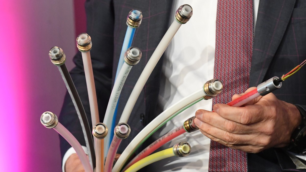 26.03.2018, Mecklenburg-Vorpommern, Klein Kedingshagen: Timotheus Hoettges, Vorstandsvorsitzender der Deutschen Telekom, zeigt beim offiziellen Start fuer den Breitbandausbau
mehrfarbige Kunststoffro ...