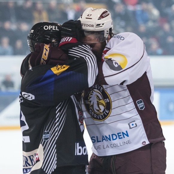 L'attaquant fribourgeois Jim Slater, gauche, se bat avec le defenseur genevois Eliot Antonietti, droite, lors de la rencontre du championnat suisse de hockey sur glace de National League entre le HC F ...