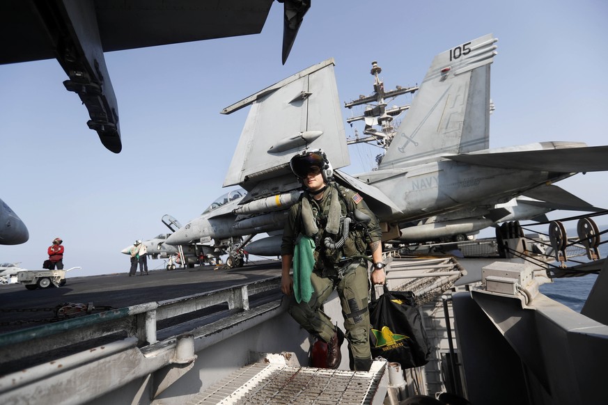 In this Tuesday, Nov. 22, 2016 photo, Lt. Jennifer Sandifer, a 27-year old fighter pilot from Austin, Texas, walks towards F/A-18E Super Hornet jet before launching from the deck of the U.S.S. Dwight  ...