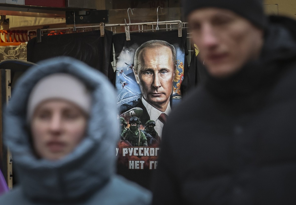 KEYPIX -- epa11844442 People walk past a T-shirt with a portrait of Russian President Vladimir Putin on display in a gift shop in the center of Moscow, Russia, 22 January 2025. EPA/YURI KOCHETKOV