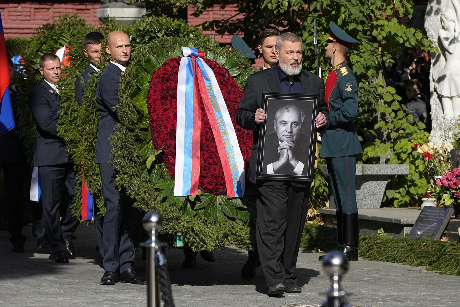 Nobel Peace Prize awarded journalist Dmitry Muratov carries a portrait of former Soviet Union President Mikhail Gorbachev during his funeral at Novodevichy Cemetery in Moscow, Russia, Saturday, Sept.  ...