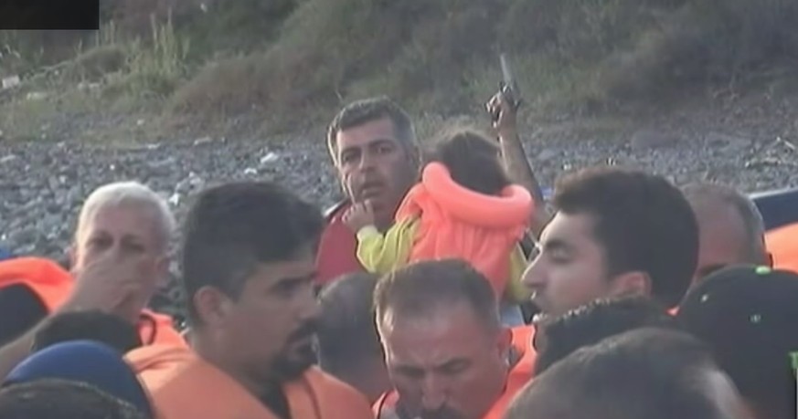 Drohgebärde vor der Abfahrt: Ein Schlepper hält eine Pistole in die Luft, um die Flüchtlinge zur Eile zu mahnen.<br data-editable="remove">