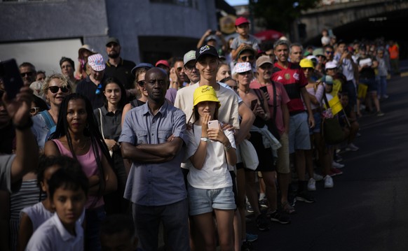 Spectators watch the riders pass during the eighth stage of the Tour de France cycling race over 186.5 kilometers (115.9 miles) with start in Dole, France, and finish in Lausanne, Switzerland, Saturda ...