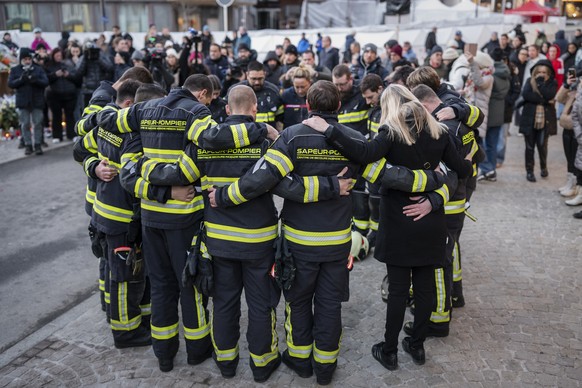 KEYPIX - A group of firefighters of the Sapeur-Pompiers de Sierre gather and hug in front of the 'Le Constellation' bar and lounge where the fire happened, in Crans-Montana, Switzerland, on  ...