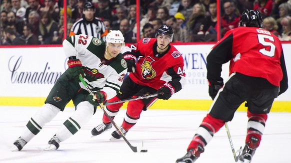 Minnesota Wild&#039;s Nino Niederreiter moves the puck between Ottawa Senators&#039; Jean-Gabriel Pageau and Cody Ceci during third period NHL hockey action in Ottawa on Tuesday, Dec. 19, 2017. (Sean  ...