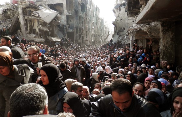 Ein älteres Bild von Menschen des Flüchtlingslagers Jarmuk, die anstehen, um Essen zu bekommen.