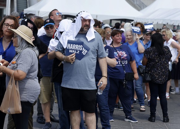 epa11544274 Supporters of Democratic presidential candidate, Vice President Kamala Harris and Democratic vice presidential candidate Minnesota Governor Tim Walz line up to attend a rally at the Univer ...