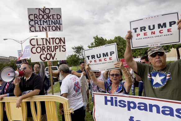 epa05581374 Supporters of Republican candidate Donald Trump hold placards and chant slogans against the Democratic party&#039;s candidate Hillary Clinton prior to the start of the Clinton&#039;s Presi ...