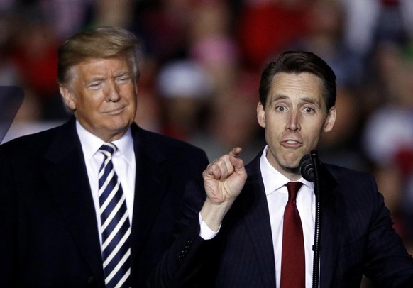 President Donald Trump listens as Republican Senate candidate Josh Hawley speaks during a campaign rally at Columbia Regional Airport, Thursday, Nov. 1, 2018, in Columbia, Mo. (AP Photo/Charlie Riedel ...