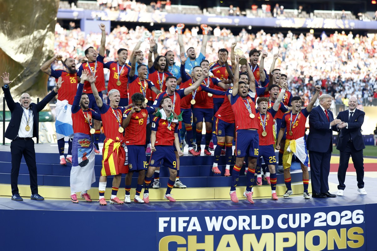 epa13122027 Rodri (C-R) and players of Spain celebrate with the World Cup Trophy as FIFA President Gianni Infantino (R) interacts with US President Donald J. Trump during the awards ceremony after the ...