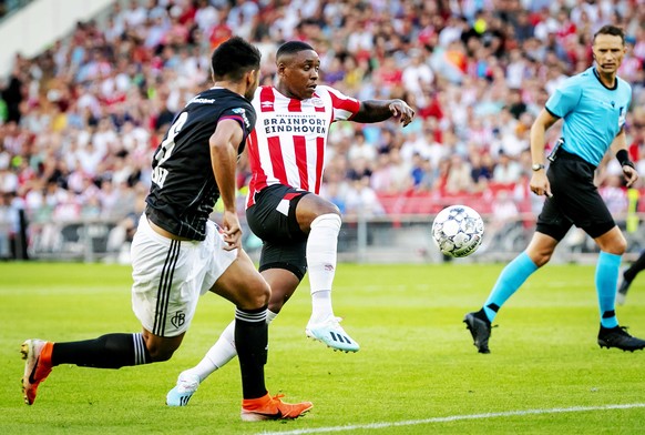 epa07735906 PSV Eindhoven player Steven Bergwijn in action against FC Basel player Omar Federico Alderete Fernandez during the second qualifying round for the Champions League match in Eindhoven, the  ...