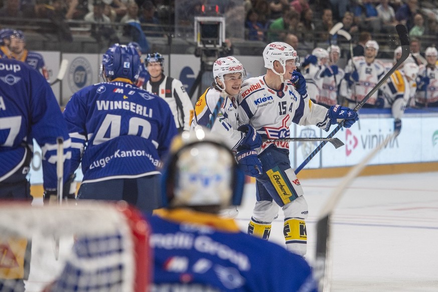 Die Spieler von Kloten mit Misch Ramel, links, und Miro Aaltonen, rechts, feiern das Tor zum 3:4 beim Eishockey Meisterschaftsspiel der National League zwischen dem EV Zug und den Kloten Flyers am Fre ...