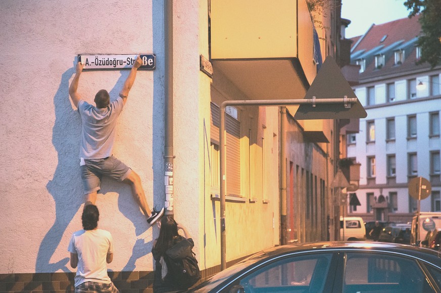 Aktivisten überkleben in Mannheim ein Strassenschild.