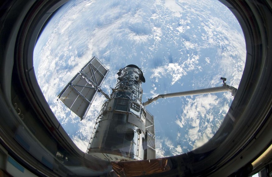 This photo provided Thursday, May 14, 2009 by NASA shows the Hubble Space Telescope following the grapple of the observatory by the shuttle's remote manipulator system Wednesday, May 13, 2009. (AP Pho ...