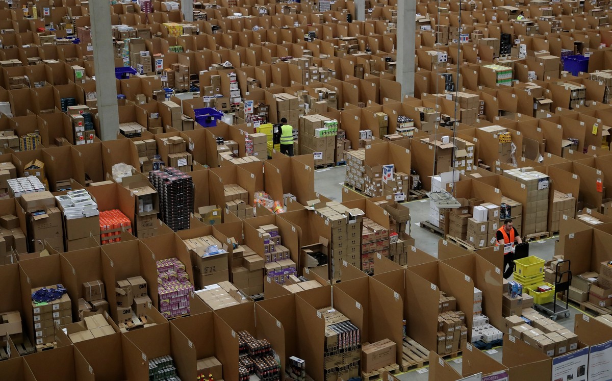 epa06355787 Workers at the Amazon logistics and distribution center in Rheinberg, Germany, 28 November 2017. The Amazon logistics center is directly connected to a 'Deutsche Post' DHL shippi ...