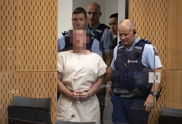 epa07441048 The man charged in relation to the Christchurch mosque massacre Brenton Harrison Tarrant (Pixelated) is lead into the dock for his appearance for murder, in the District Court, Christchurc ...